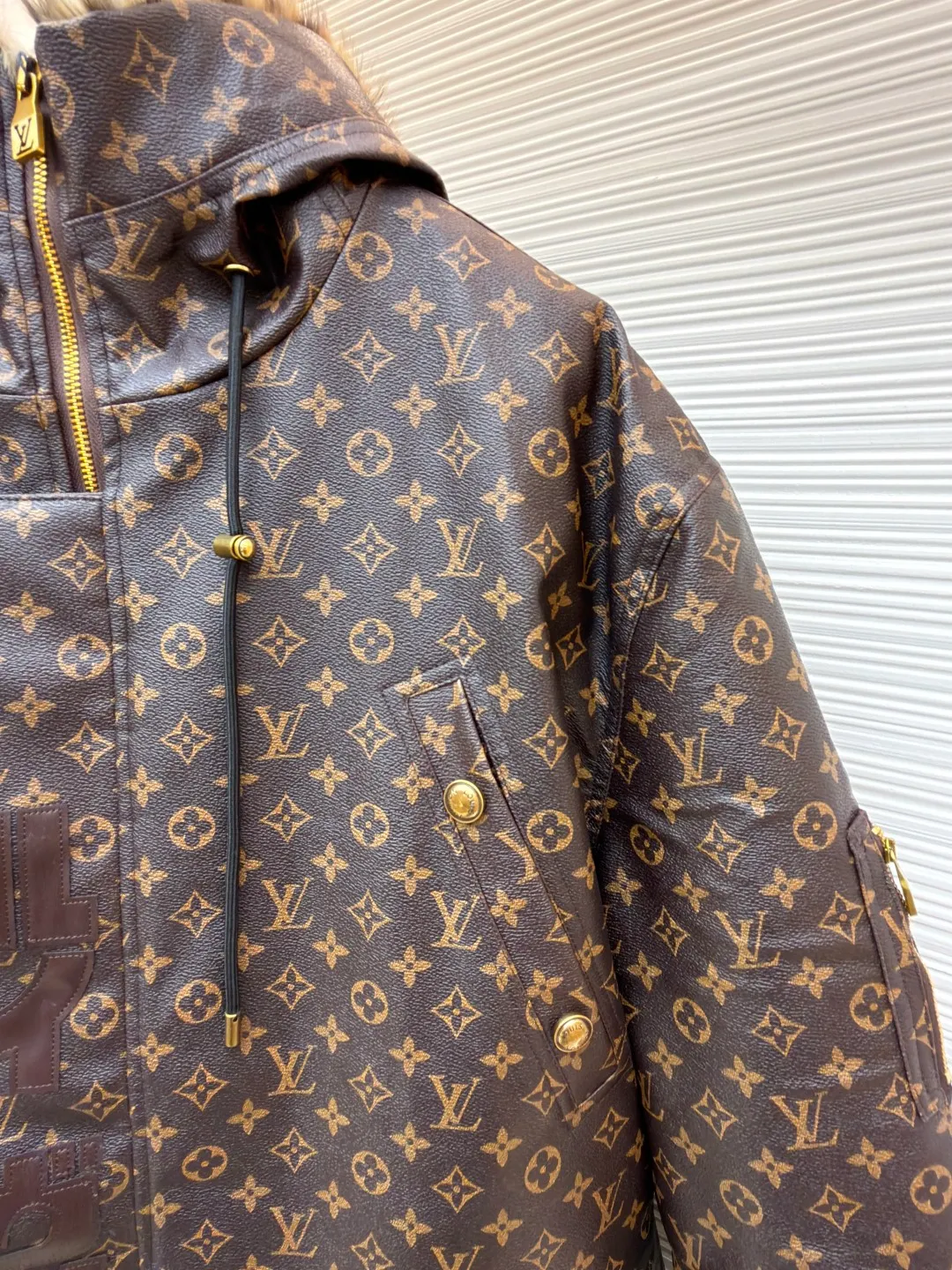 LOUIS VUITTON letter print hooded jacket ●Original version: Purchased and developed for 69999 ●Item number: 1681985-E40 ●Fabric: cotton fabric ●Technology: printing production ●Color: brown ●Version: fitted version ●Weight: about 1810 grams ●Size: 46-48-50-52 ●Description: This printed jacket is made of embossed leather fabric with a dark brown base and is fully printed with the classic Monogram pattern. The embossing process gives the logo a three-dimensional texture. The edge of the hood is spliced ​​with a natural fur collar, and the brim is equipped with an adjustable drawstring (metal rope buckle) to enhance warmth and style. The placket is double-closed with a two-way metal zipper and brass snap buttons. The zipper puller and snap button are both engraved with the brand logo, which is thick and durable. The body is designed with multiple pockets, and the pockets are edged with the same material + metal snap buttons for reinforcement. The left sleeve is equipped with a hidden adjustment tab. The interior is filled with high-fill down cotton, and the stitching adopts diamond-shaped quilting technology to prevent the filling from shifting. The seams are edged with leather of the same color, and the overall wiring is precise, taking into account warmth retention and luxurious texture. The overall wiring is straight and delicate, the fabric is comfortable and soft, and the color is consistent without color difference. It can be matched with the same style to create a fashionable look and control various occasions. Customized accessories, complete with three standards, same style for men and women!